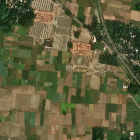Brick kiln beside dense green fields in Bangladesh